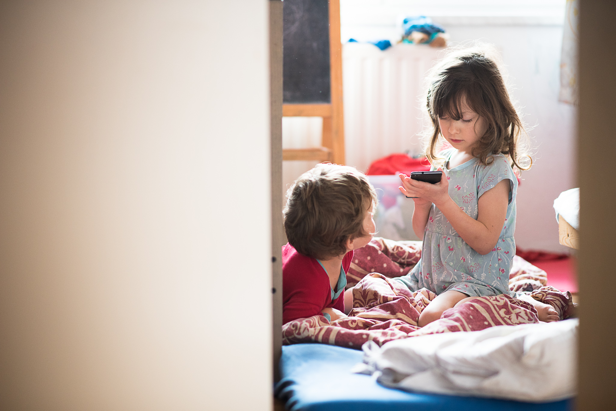 Ranní sourozenecká idylka s mobilem v ruce